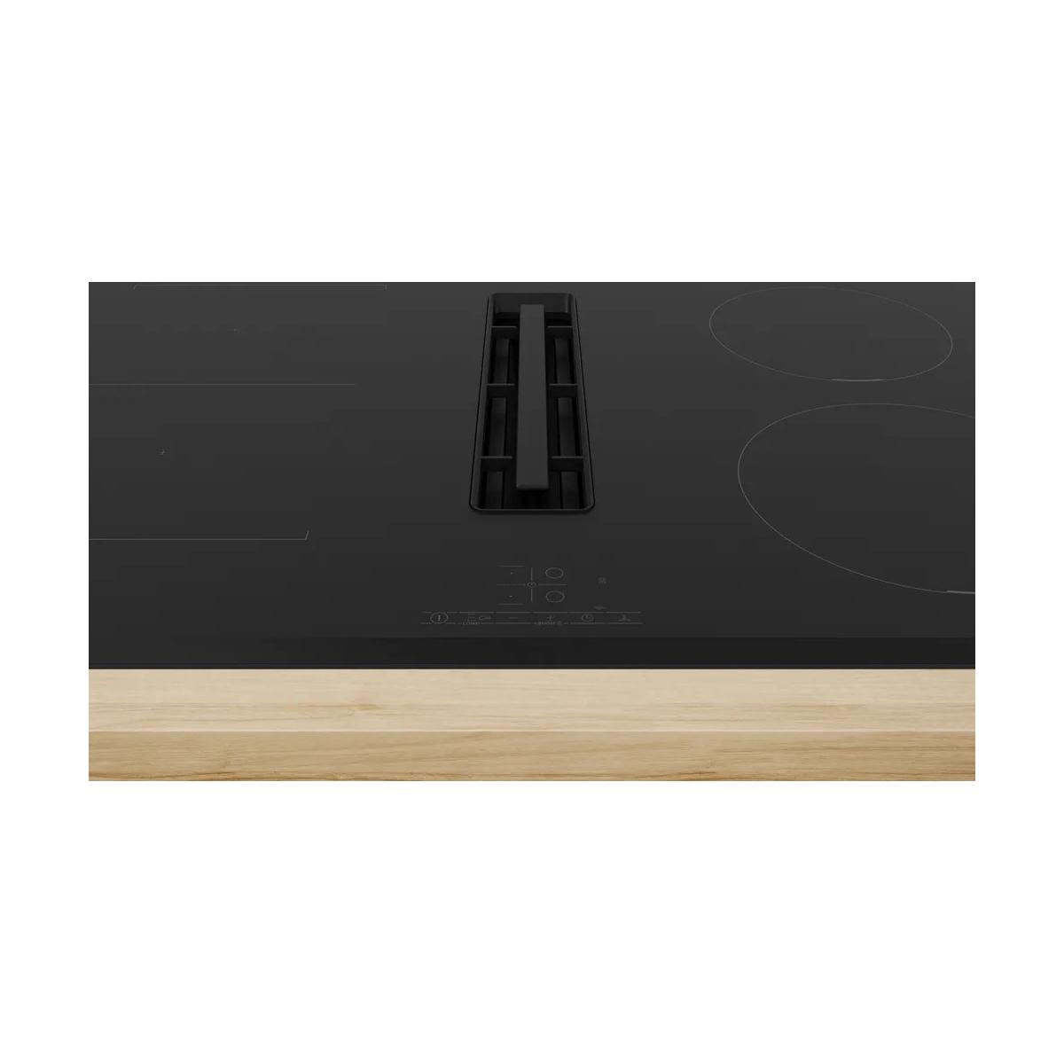 Placa de inducción negra con extractor integrado y encimera de madera.