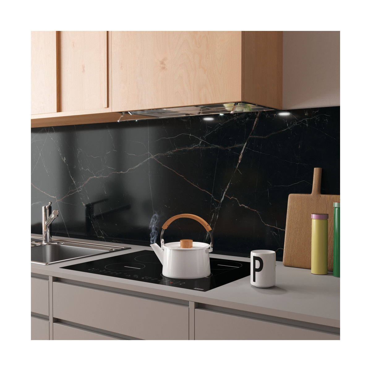 Modern bir mutfakta indüksiyonlu ocakta buğulayan beyaz bir demlik.