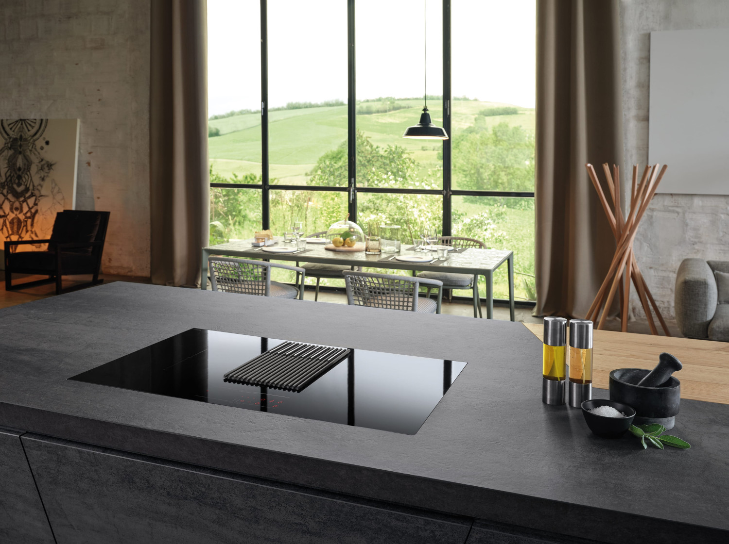 Cucina moderna con isola, zona pranzo e vista sul verde.