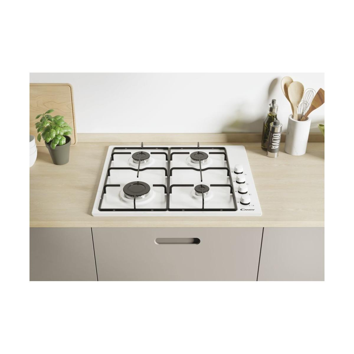 Una placa de gas blanca con cuatro quemadores sobre una encimera de madera.