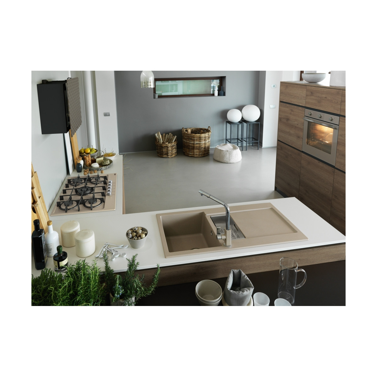 Una cucina moderna con lavello, piano cottura e forno. Decorata con cesti e piante.