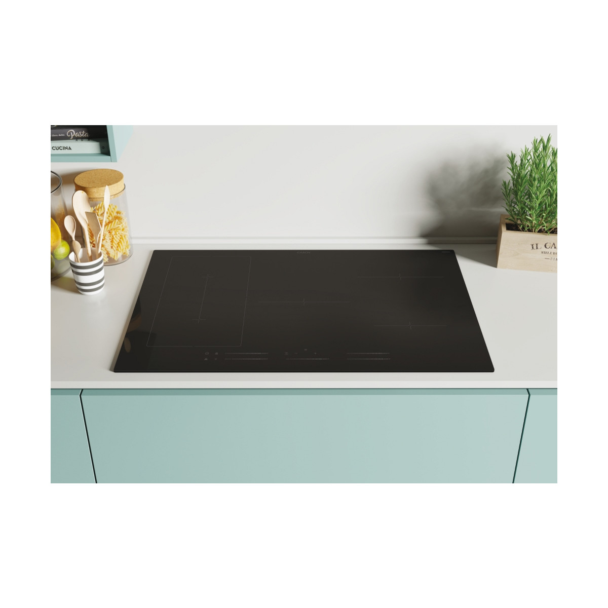 Un piano cottura a induzione nero su un piano di lavoro chiaro con utensili da cucina.