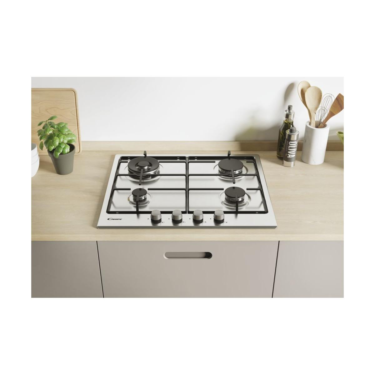 Encimera de gas de acero inoxidable con cuatro quemadores y utensilios de cocina.