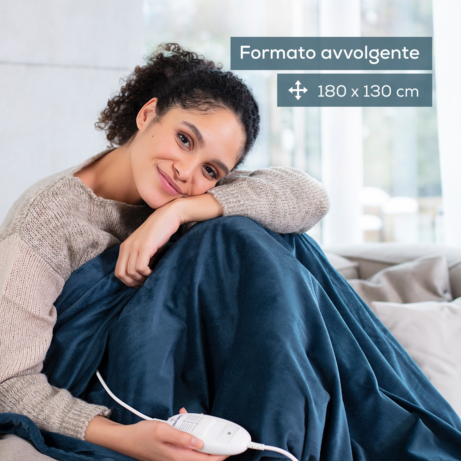 Donna avvolta in coperta termica blu, sorride. Coperta 180x130 cm.