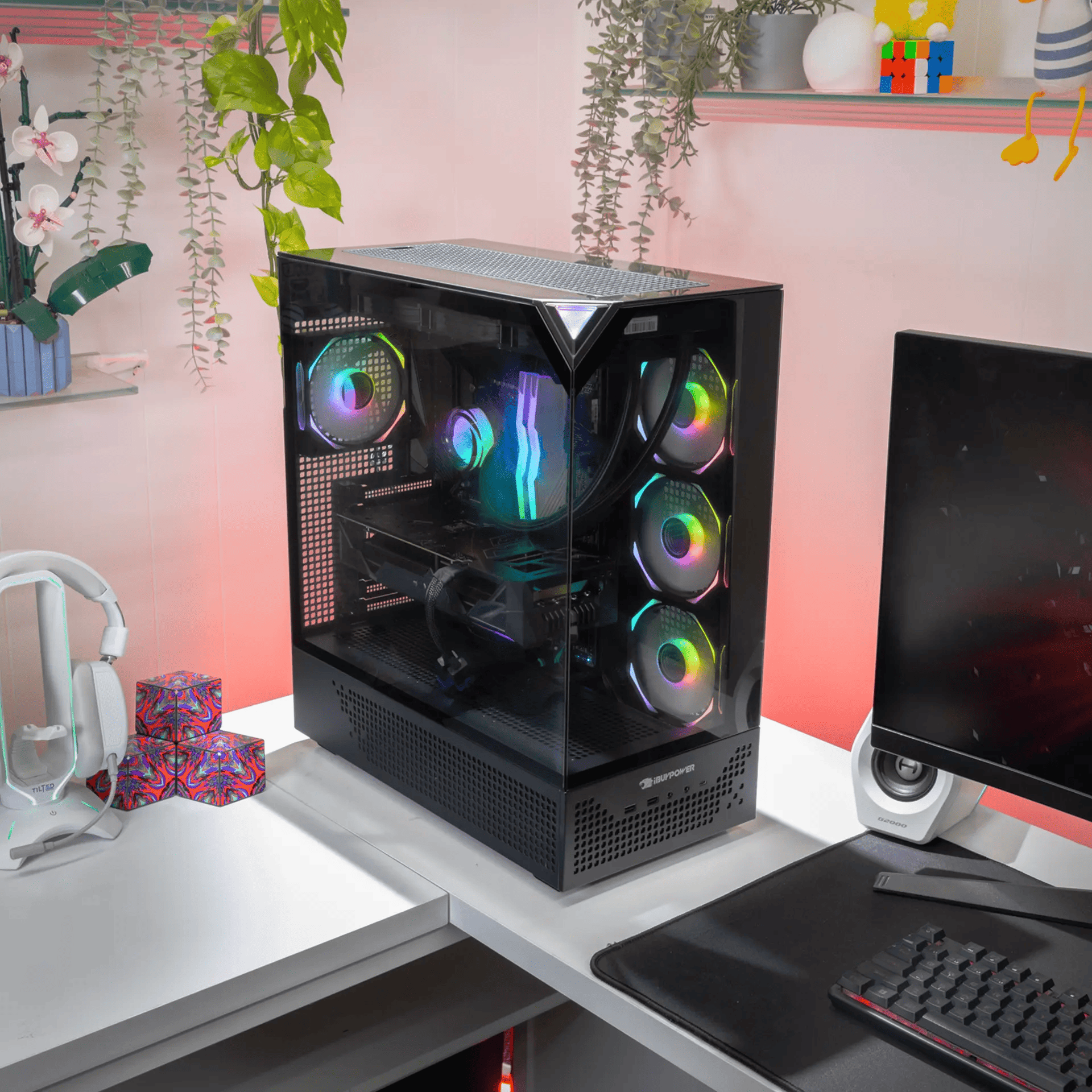 Un PC para juegos con ventiladores RGB en un escritorio con auriculares y monitor.