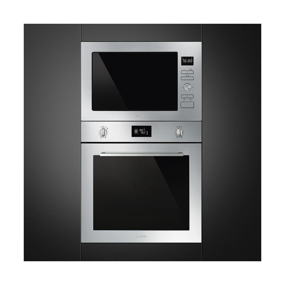 Un microondas y horno de acero inoxidable integrados en gabinetes oscuros.