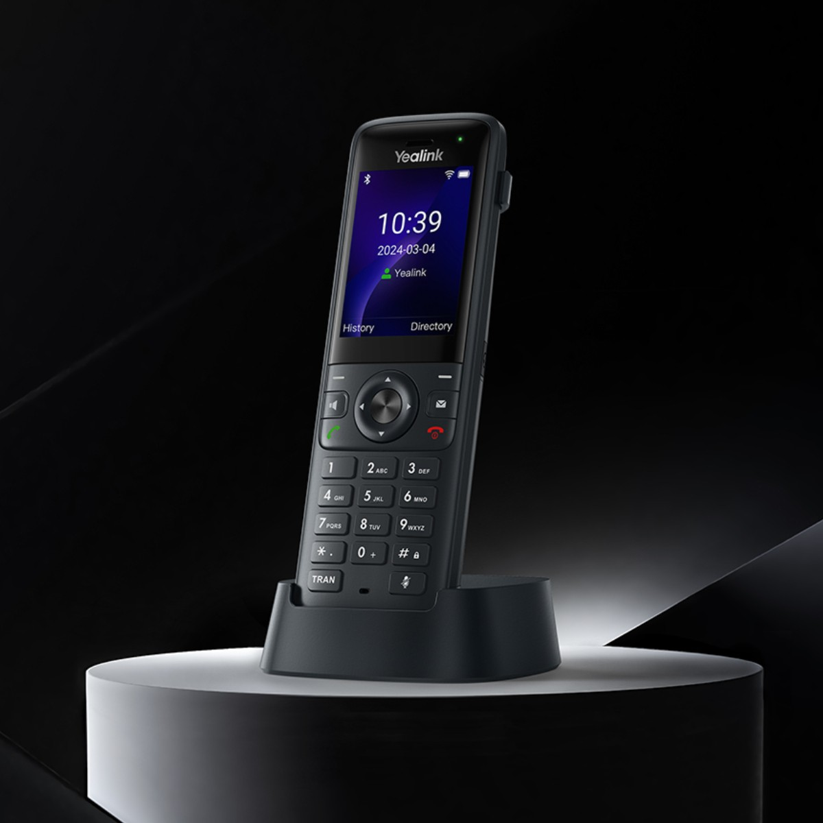 Ekranlı, tuş takımına ve şarj istasyonuna sahip siyah bir Yealink kablosuz telefon.