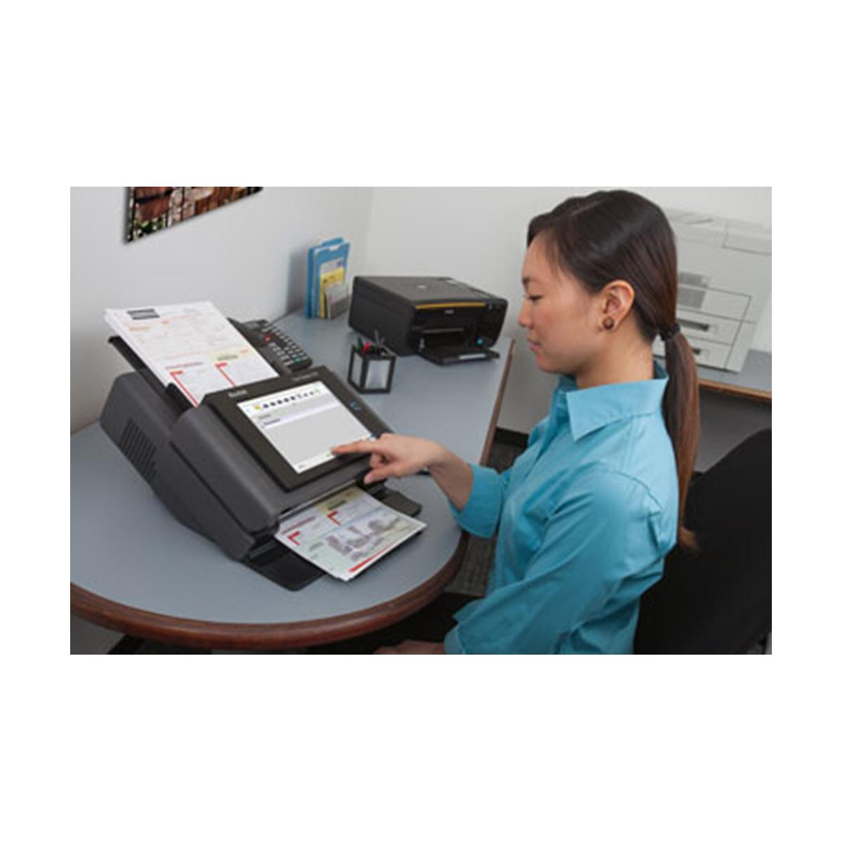 A woman uses a scanner with a touchscreen. A printer is in the background.