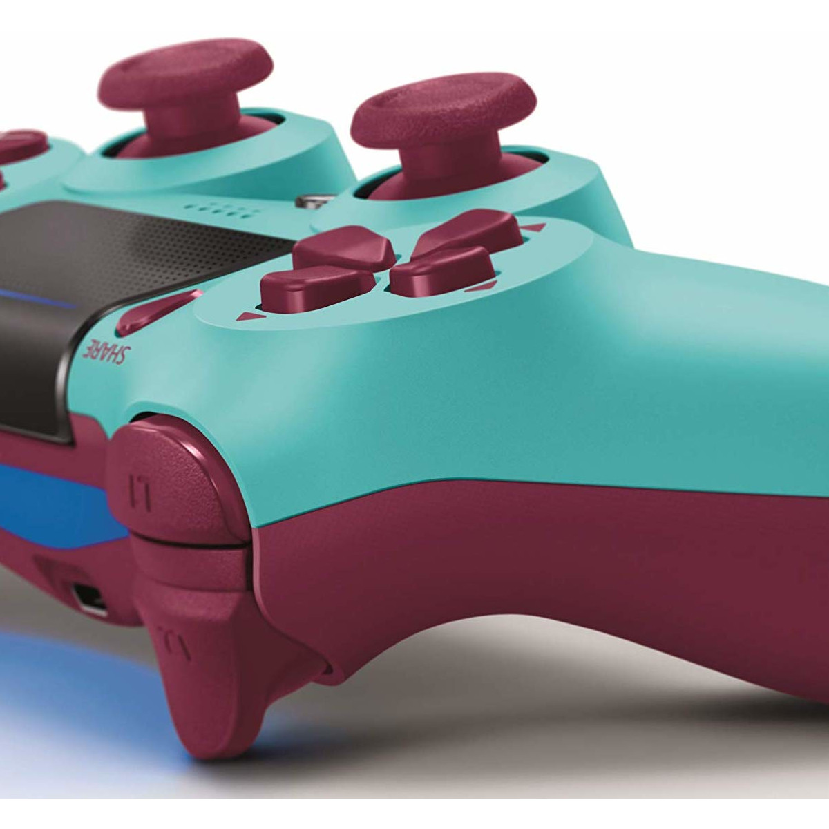 Türkisfarbener Controller mit burgunderroten Knöpfen und Joysticks.