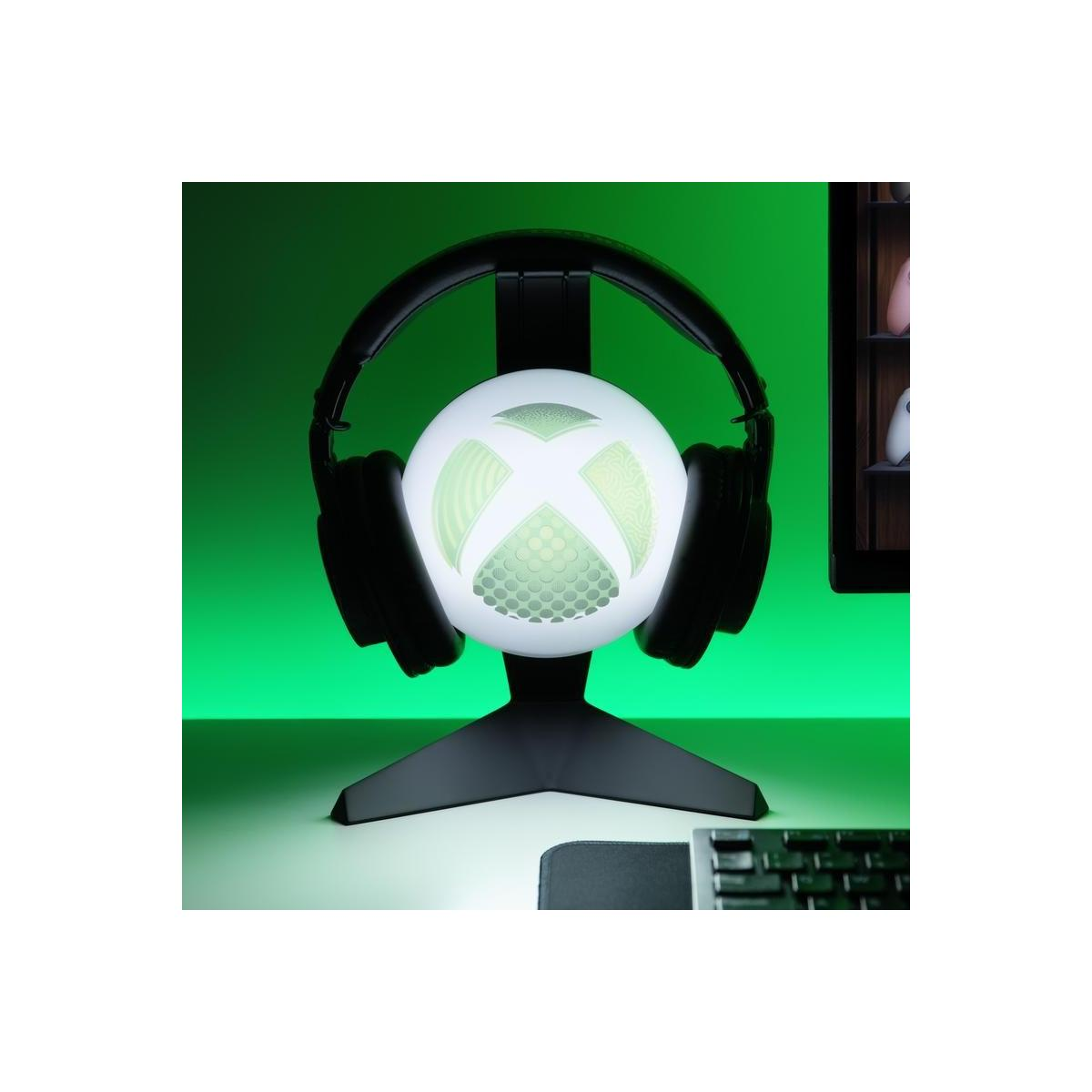 Świecąca kula Xbox ze słuchawkami na stojaku, zielone tło.