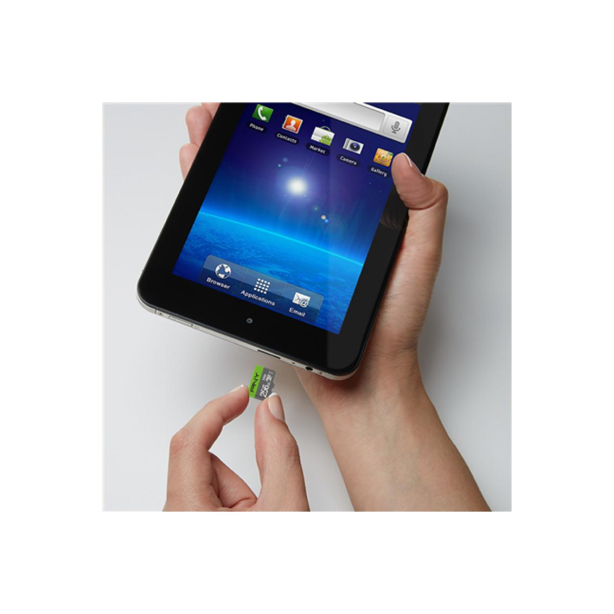 Eine Hand steckt eine grüne Speicherkarte in ein Tablet.