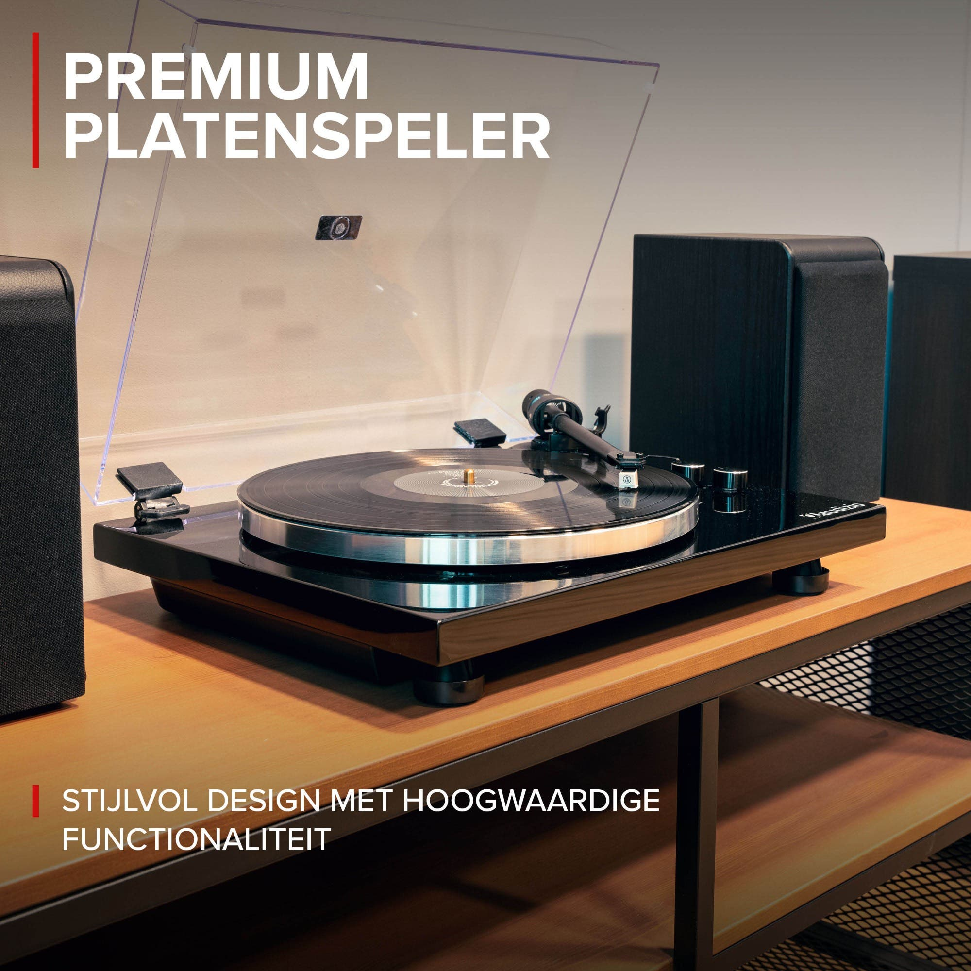 Een platenspeler met zwarte luidsprekers op een houten tafel.