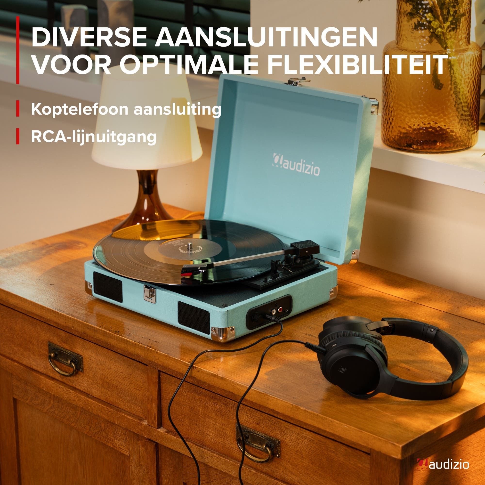 Un tocadiscos azul claro con un disco de vinilo y auriculares en una cómoda de madera.