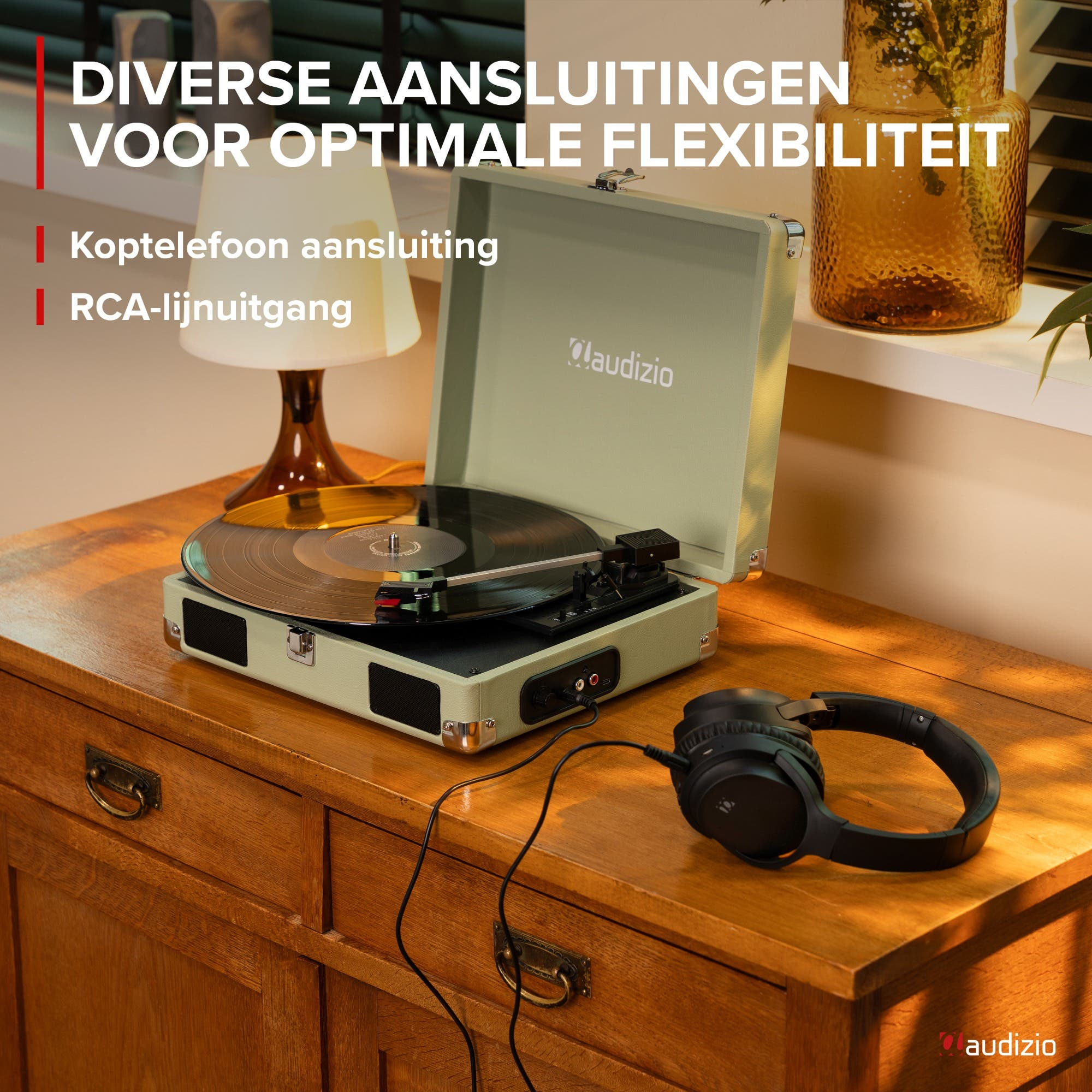 A record player with vinyl record, headphones, and a glass vase.