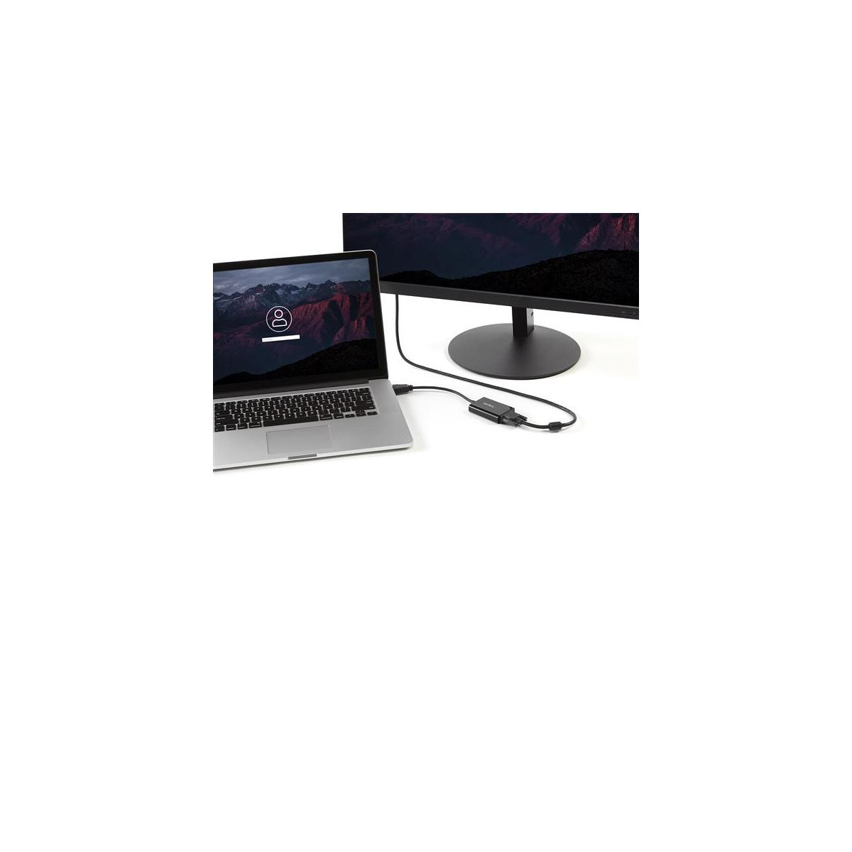 Un portátil se conecta a un monitor externo mediante un adaptador.
