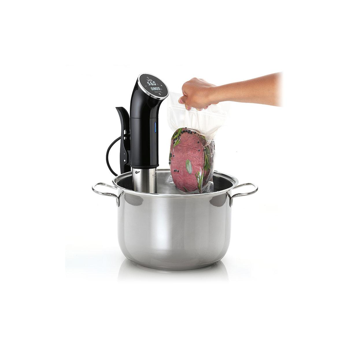 Una bolsa sellada al vacío de carne con hierbas se coloca en una olla con un dispositivo sous vide.