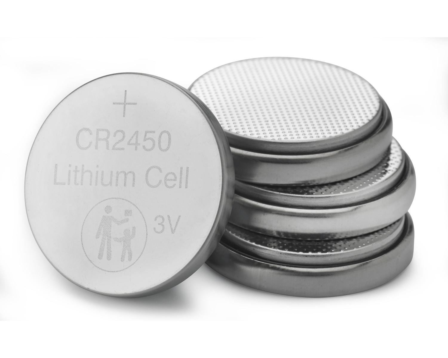 Een zilveren CR2450 lithium knoopcelbatterij en een stapel vergelijkbare batterijen op witte achtergrond.