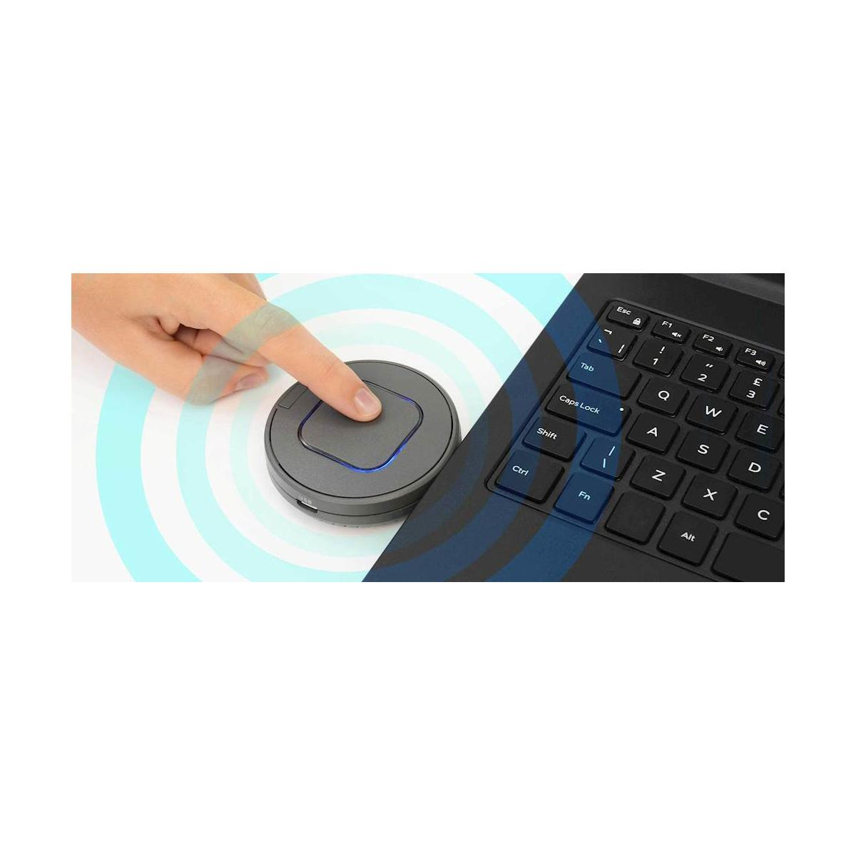 Un dedo presiona un dispositivo redondo y gris junto al teclado de un portátil.
