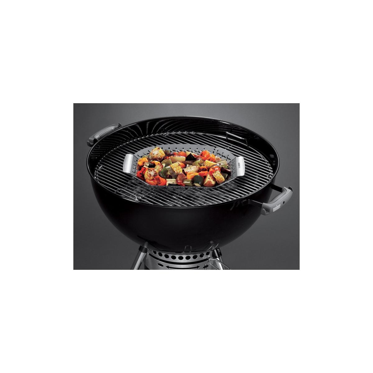 Ein Grillkorb mit Gemüse, wie Zucchini, Paprika und Mais, auf einem Grill.