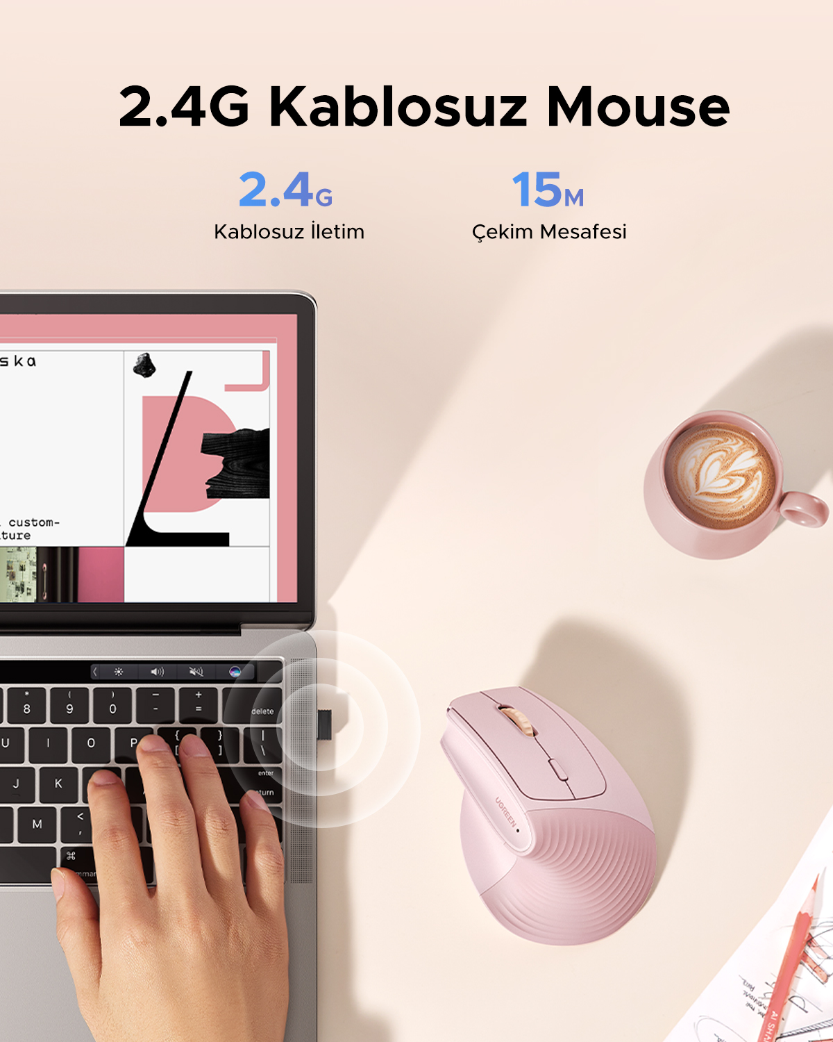 Różowa mysz bezprzewodowa obok laptopa i filiżanki kawy.
