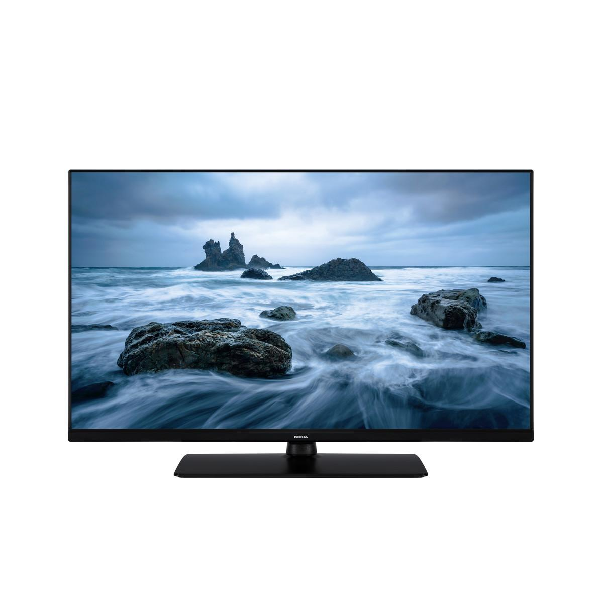 Una moderna TV a schermo piatto mostra uno scenario marino tempestoso con rocce frastagliate e onde che si infrangono.