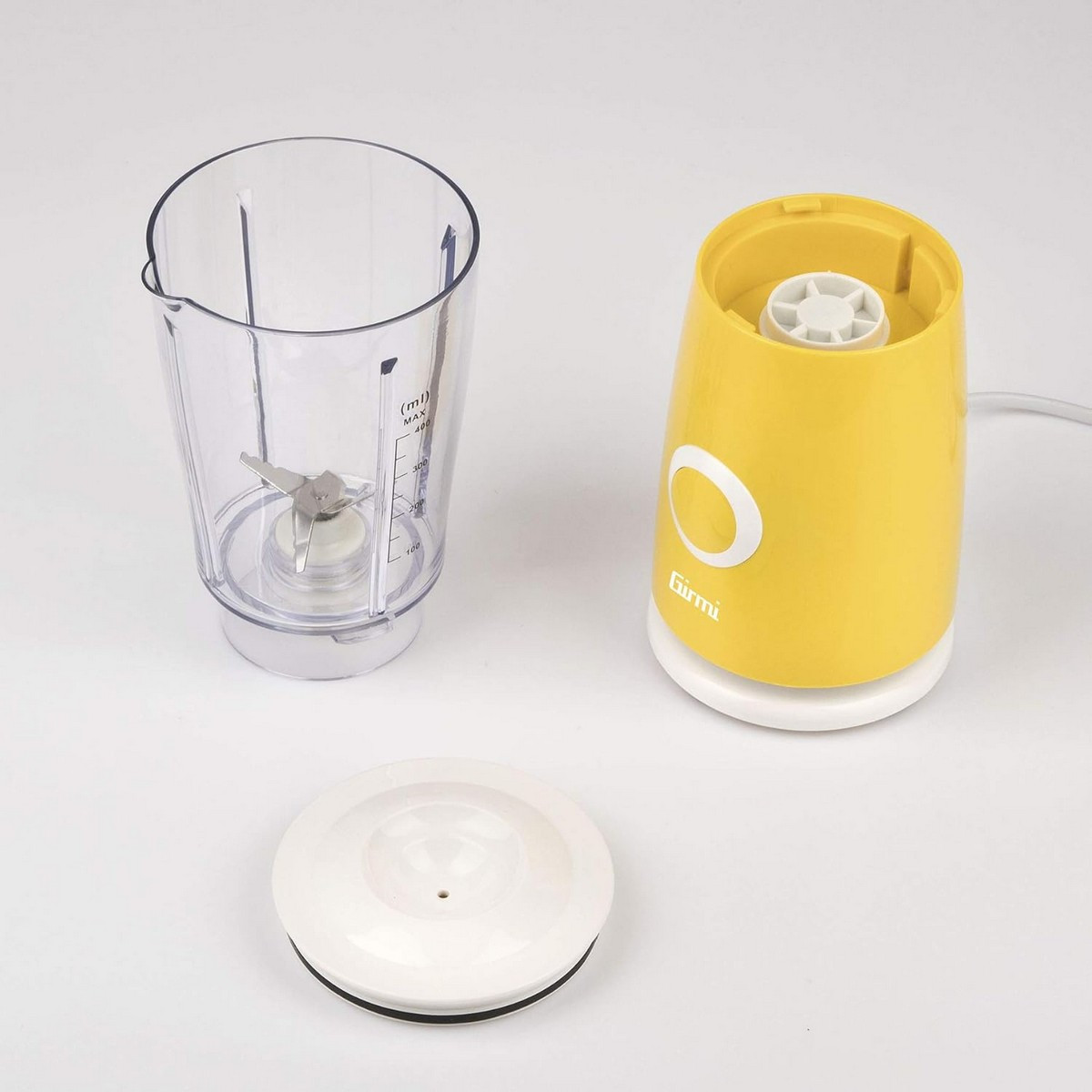 Base frullatore gialla, caraffa trasparente con lame e coperchio bianco.