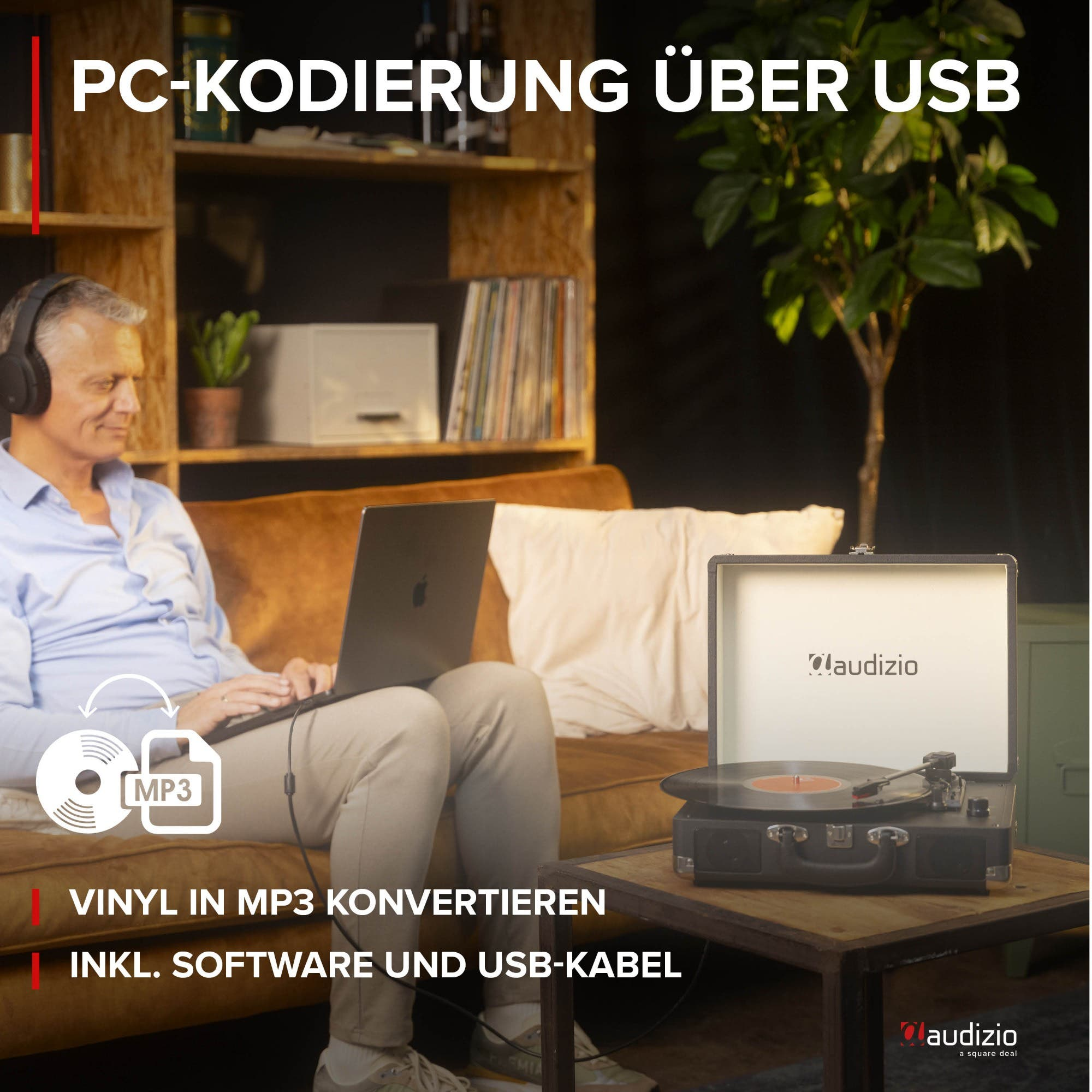Man with headphones converts vinyl to MP3 via laptop and record player.