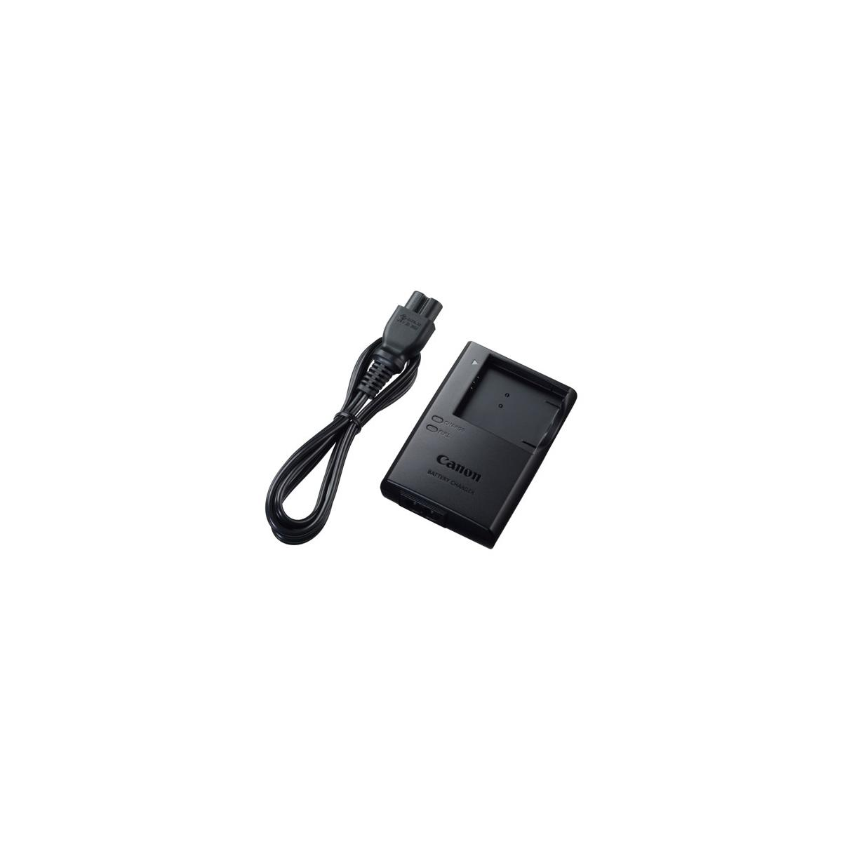 Cargador de batería Canon negro con cable sobre fondo blanco.