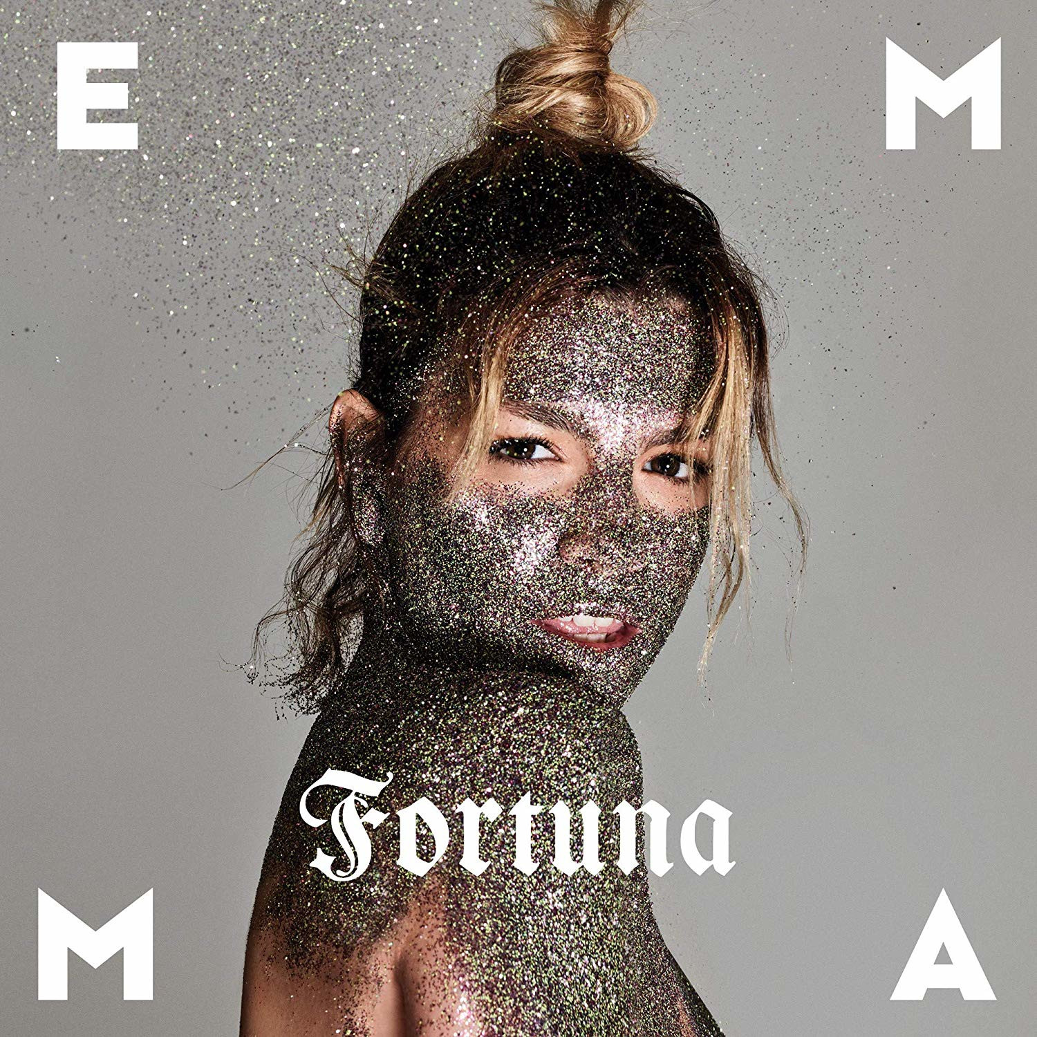 Una donna con viso e corpo coperti di glitter, con scritto "Fortuna".