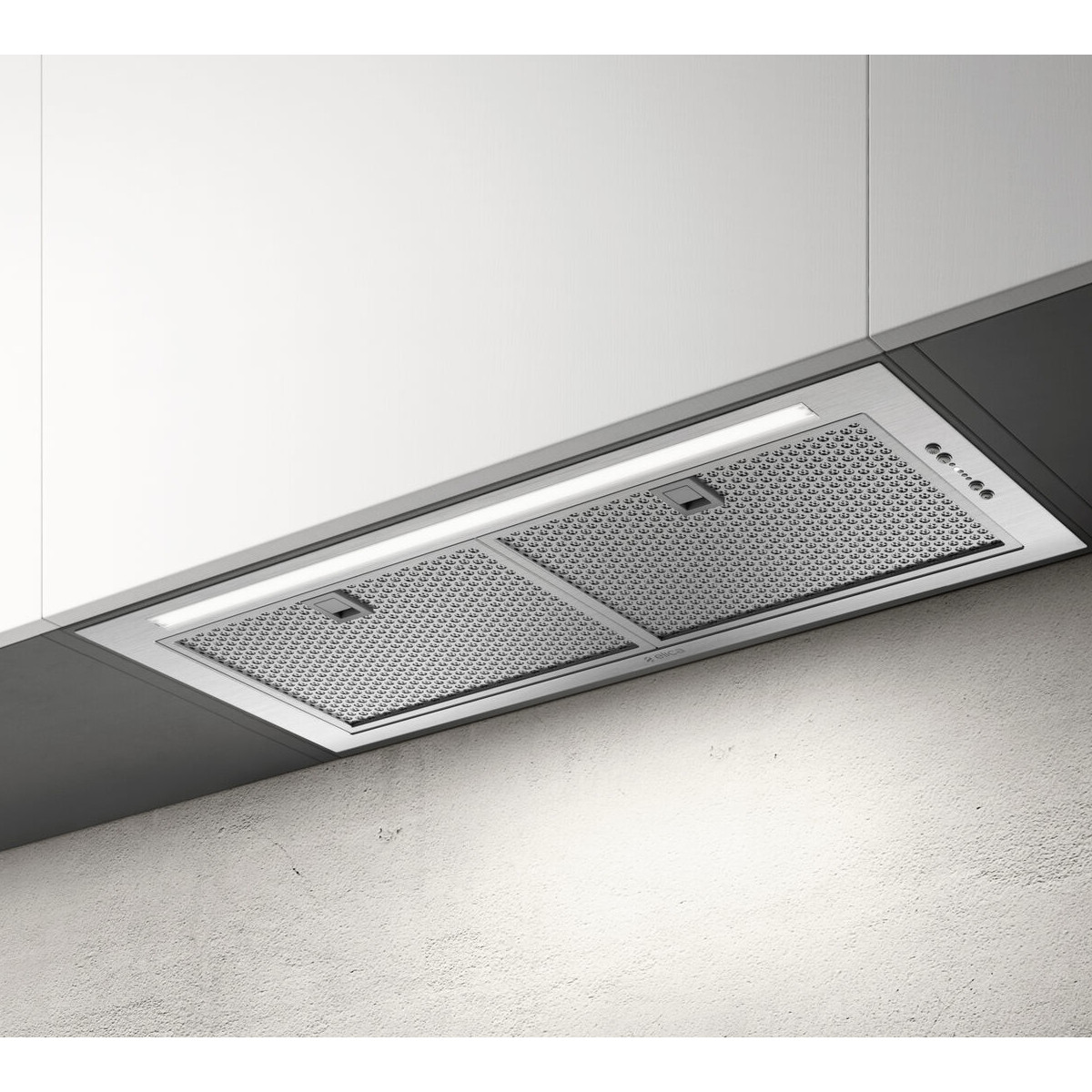 Una moderna cappa in acciaio inox con striscia luminosa sopra un muro testurizzato.