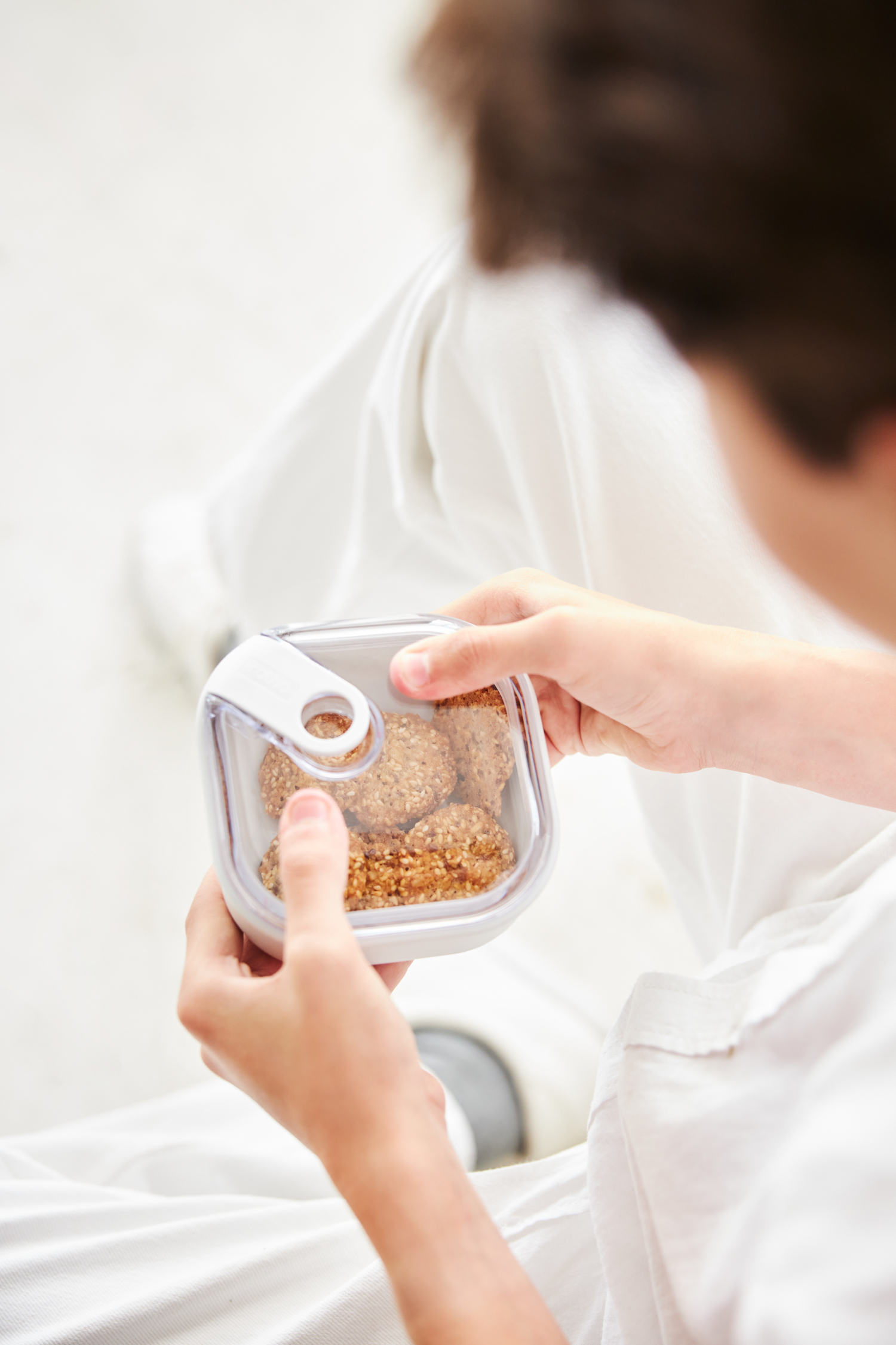 Una persona tiene un contenitore trasparente pieno di biscotti.