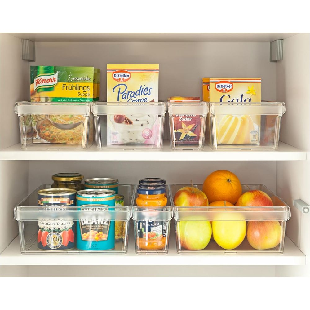 Scaffali con alimenti in contenitori trasparenti: zuppe, dessert, frutta e verdura.