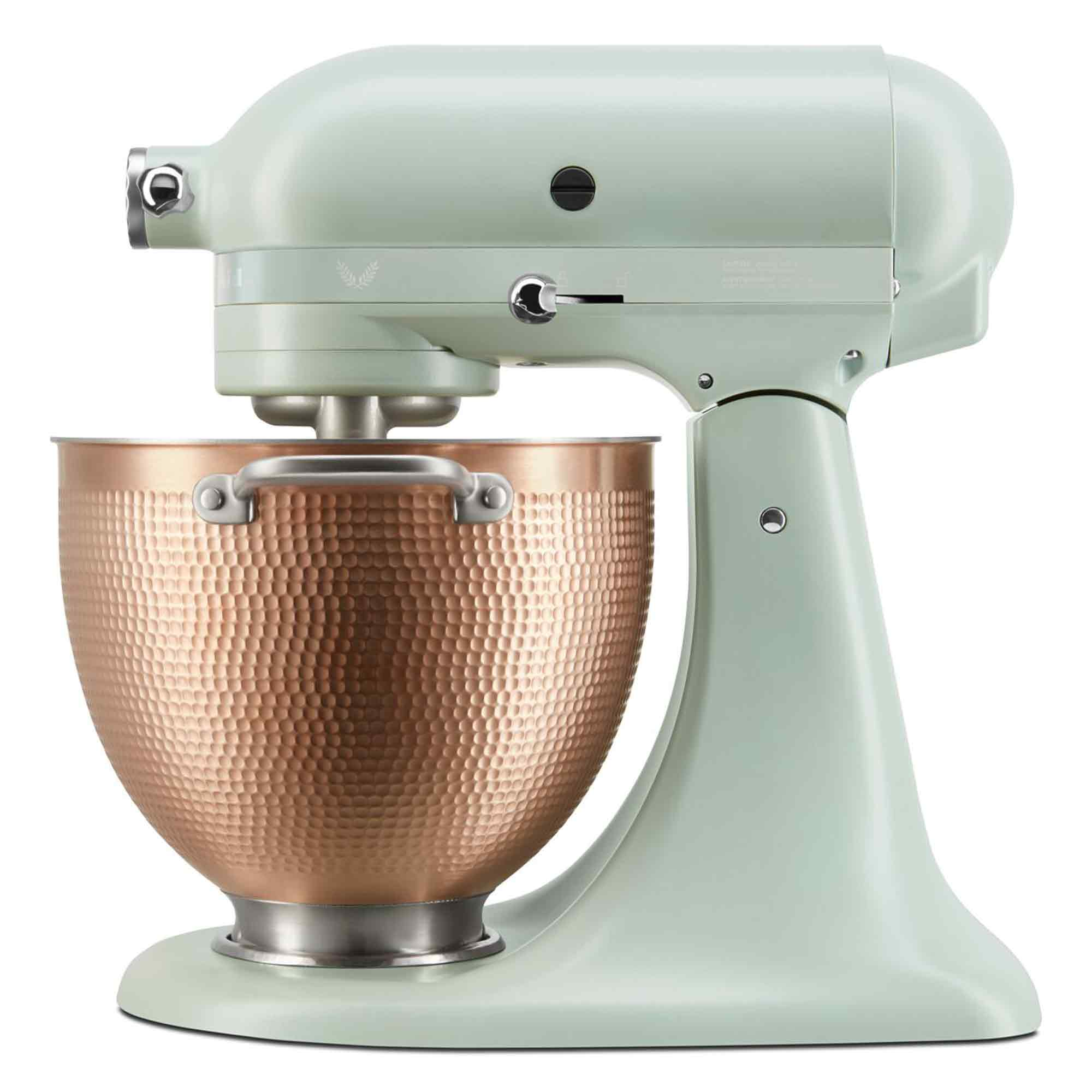 Ein hellgrüner Standmixer mit einer gehämmerten Kupfer-Rührschüssel und silbernen Akzenten.