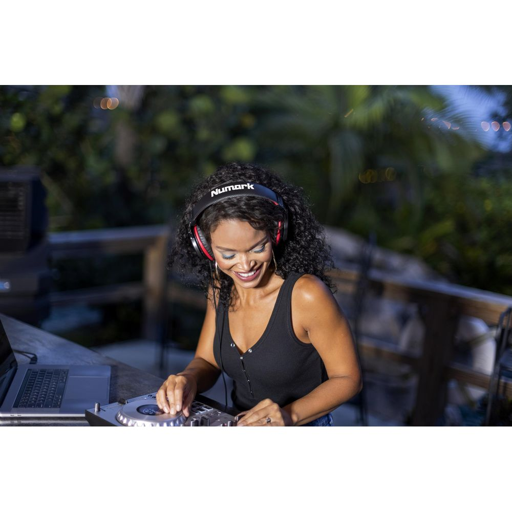 Une femme portant un casque DJ sur une console en extérieur.