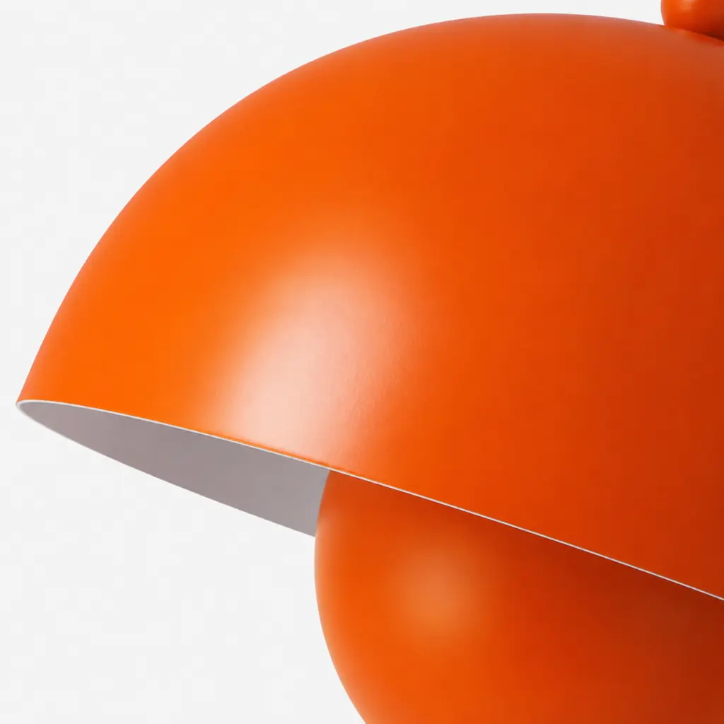 Lámpara naranja con dos pantallas semicirculares, primer plano.