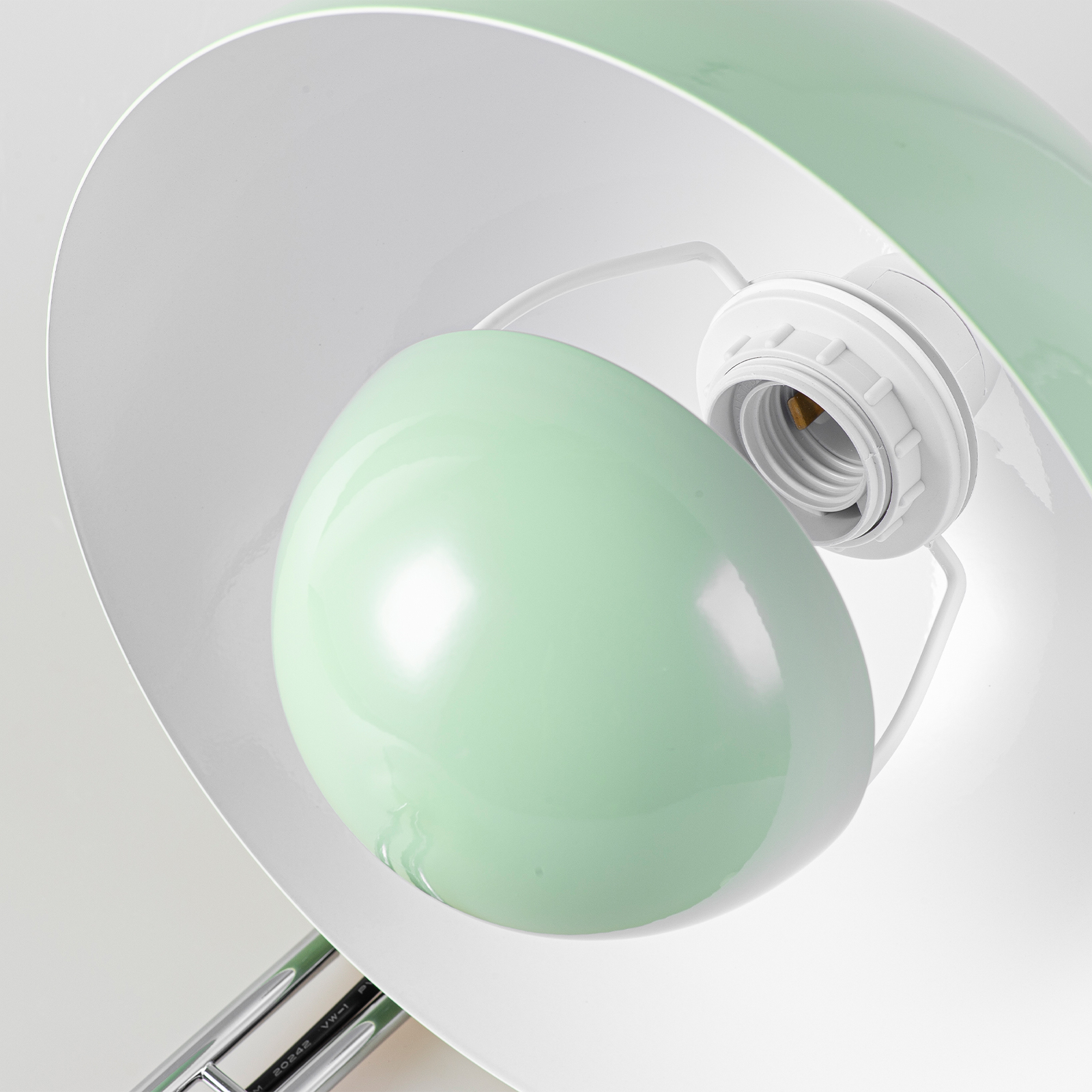 Una pantalla de lámpara verde claro con un portalámparas blanco.