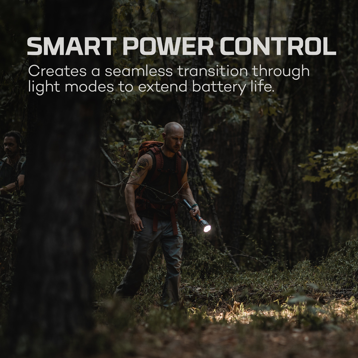 Ein Mann mit Rucksack und Taschenlampe geht im Wald. Text: SMART POWER CONTROL.