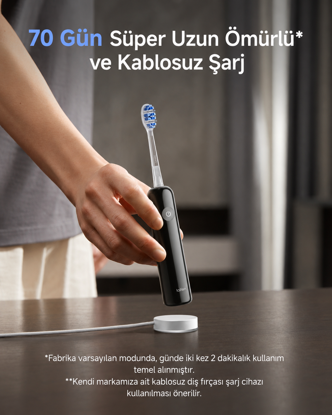 Bir el, beyaz bir şarj istasyonunun üzerinde siyah bir elektrikli diş fırçası tutuyor.