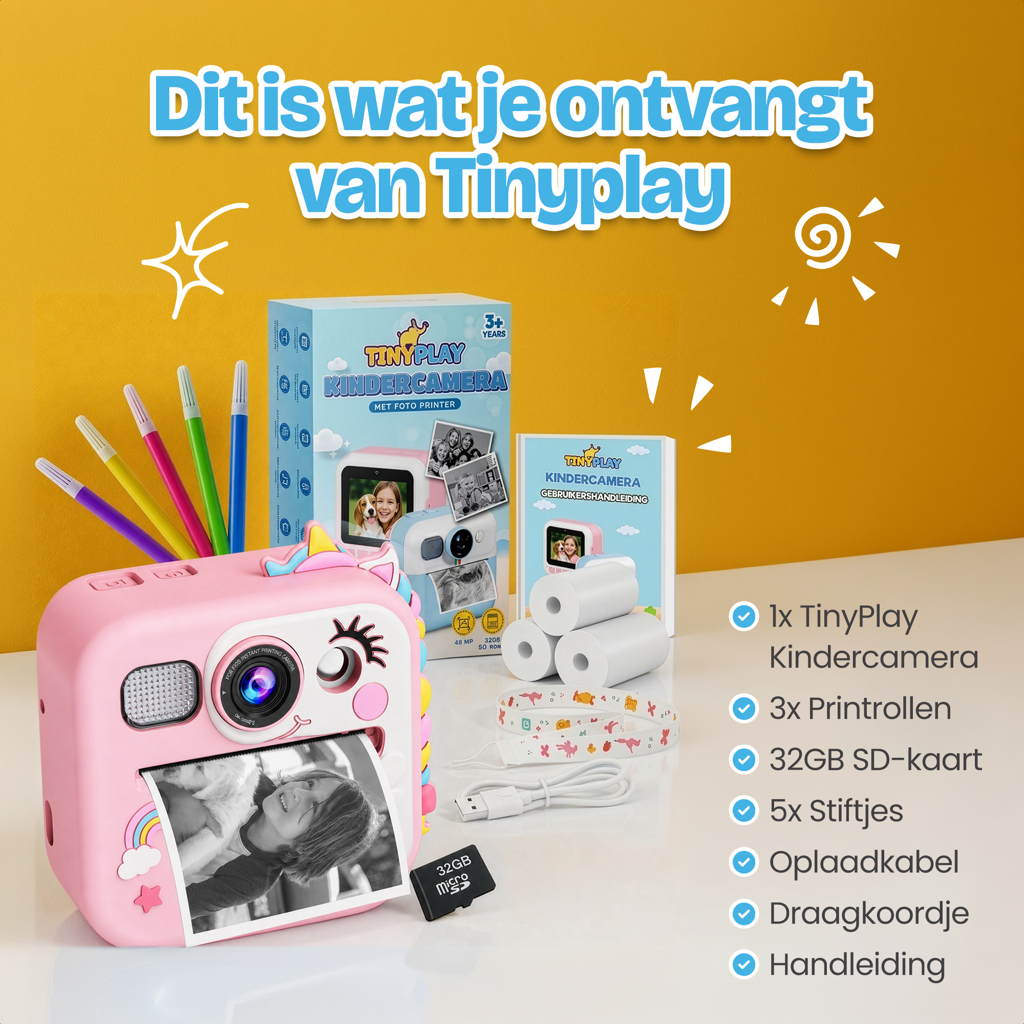 Roze eenhoorn camera met pennen, papierrollen, oplaadkabel en SD-kaart.