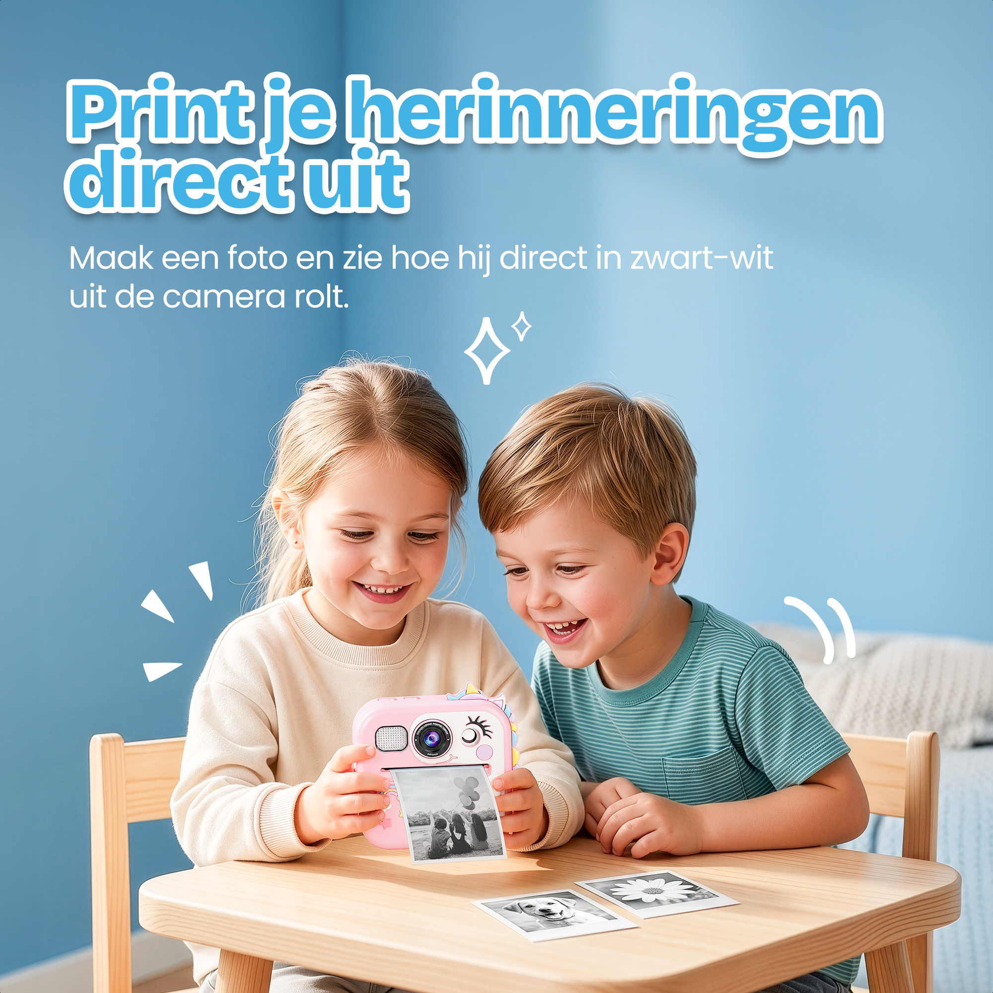 Twee kinderen printen foto's met roze camera. Zwart-wit foto's liggen op tafel.