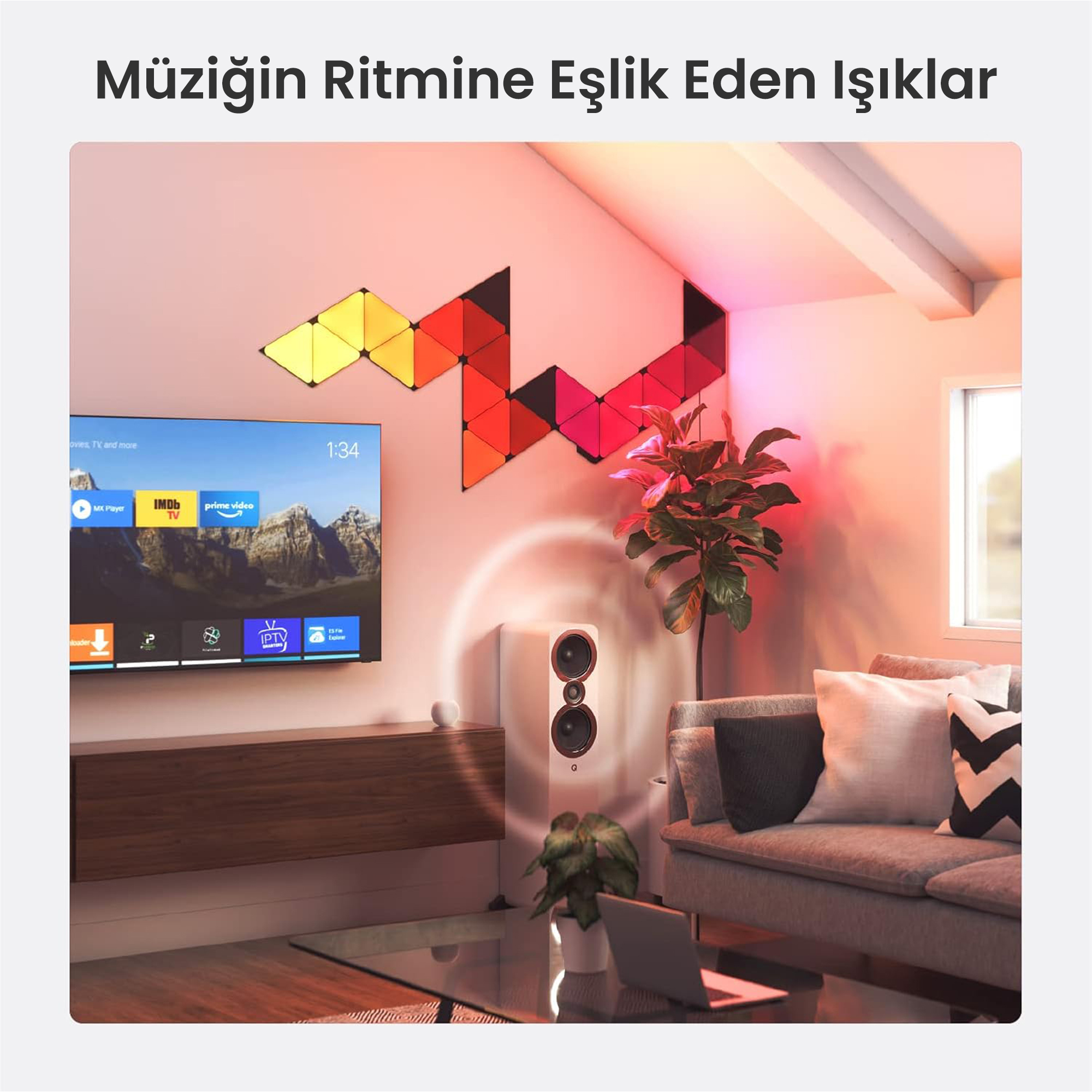 TV, renkli duvar panelleri, hoparlör ve kanepenin olduğu oturma odası.