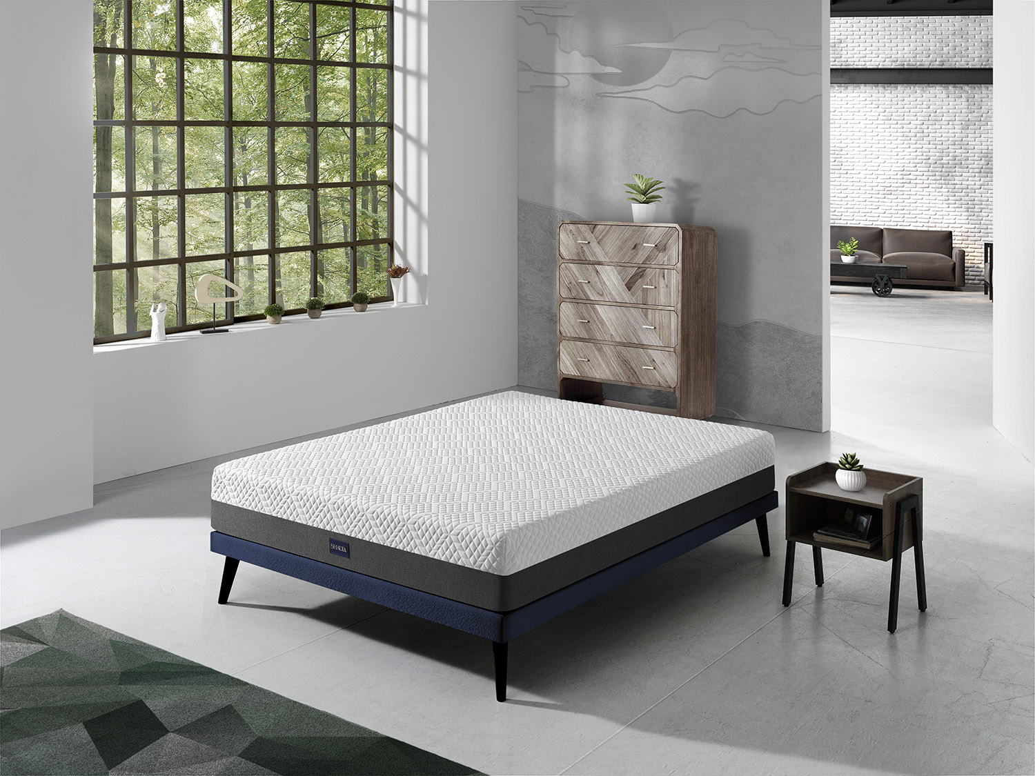 Colchón blanco sobre base azul con mesita de noche de madera junto a ventana.