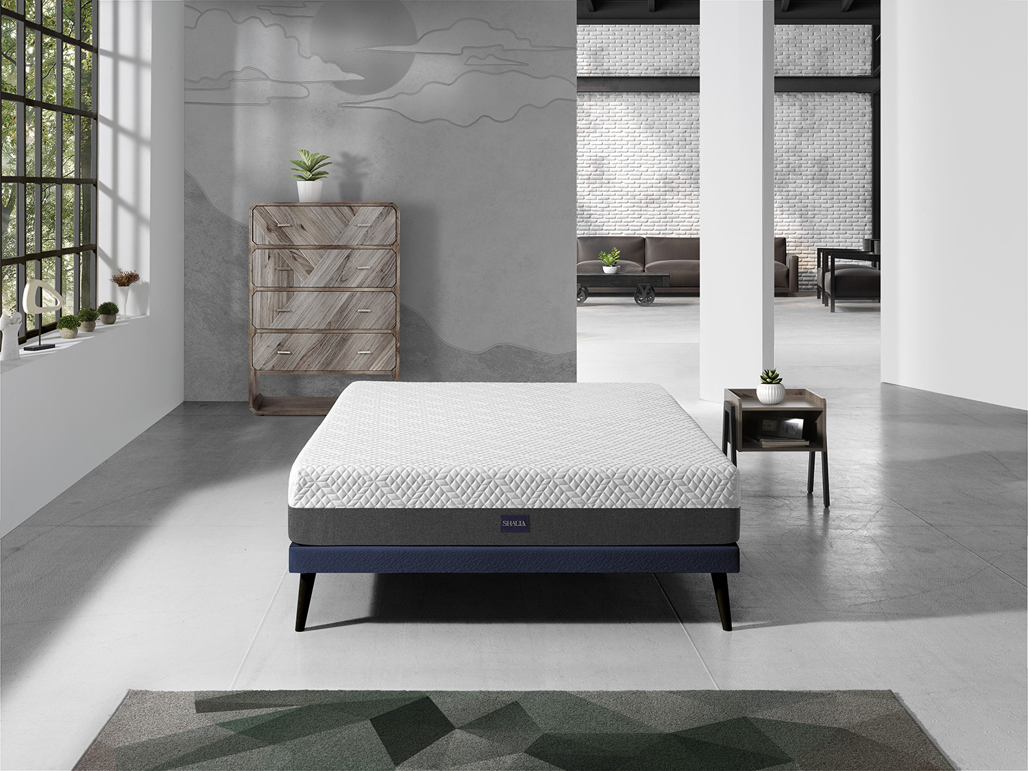 Un colchón blanco con marco gris y azul descansa en una habitación moderna.