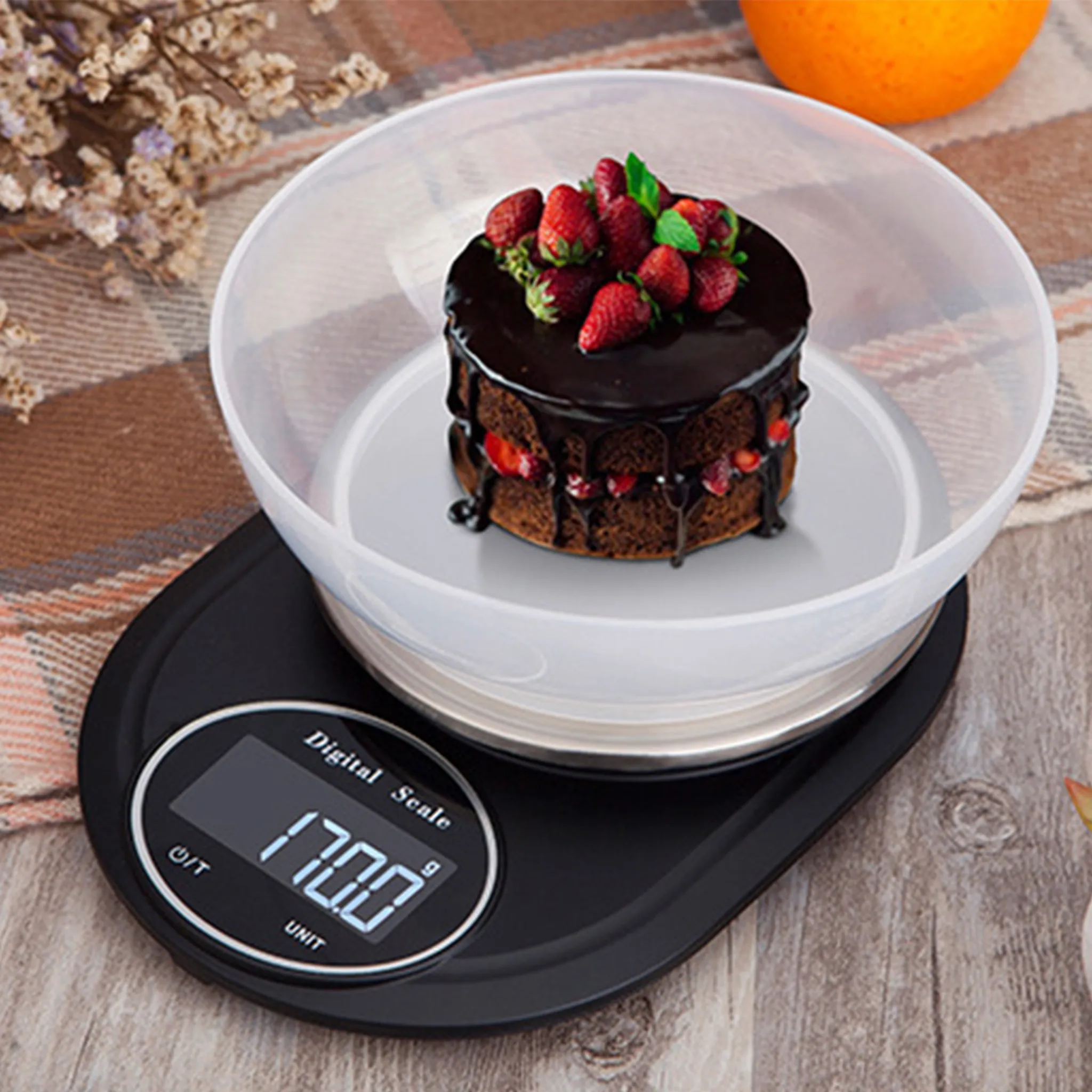 Ein Schokoladenkuchen mit Erdbeeren auf einer digitalen Küchenwaage.