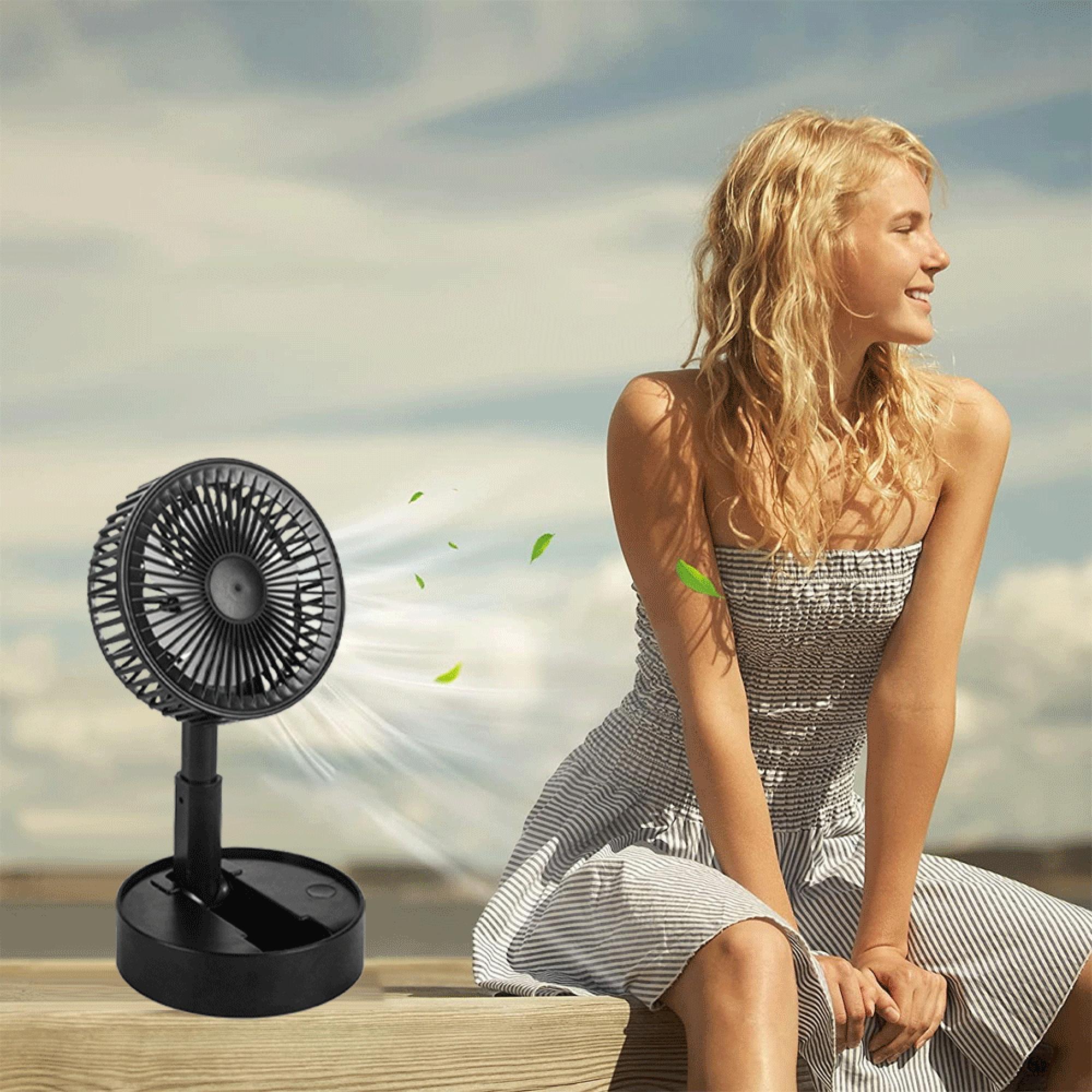 Ein schwarzer Ventilator bläst Luft und Blätter auf einer Frau in einem gestreiften Kleid.