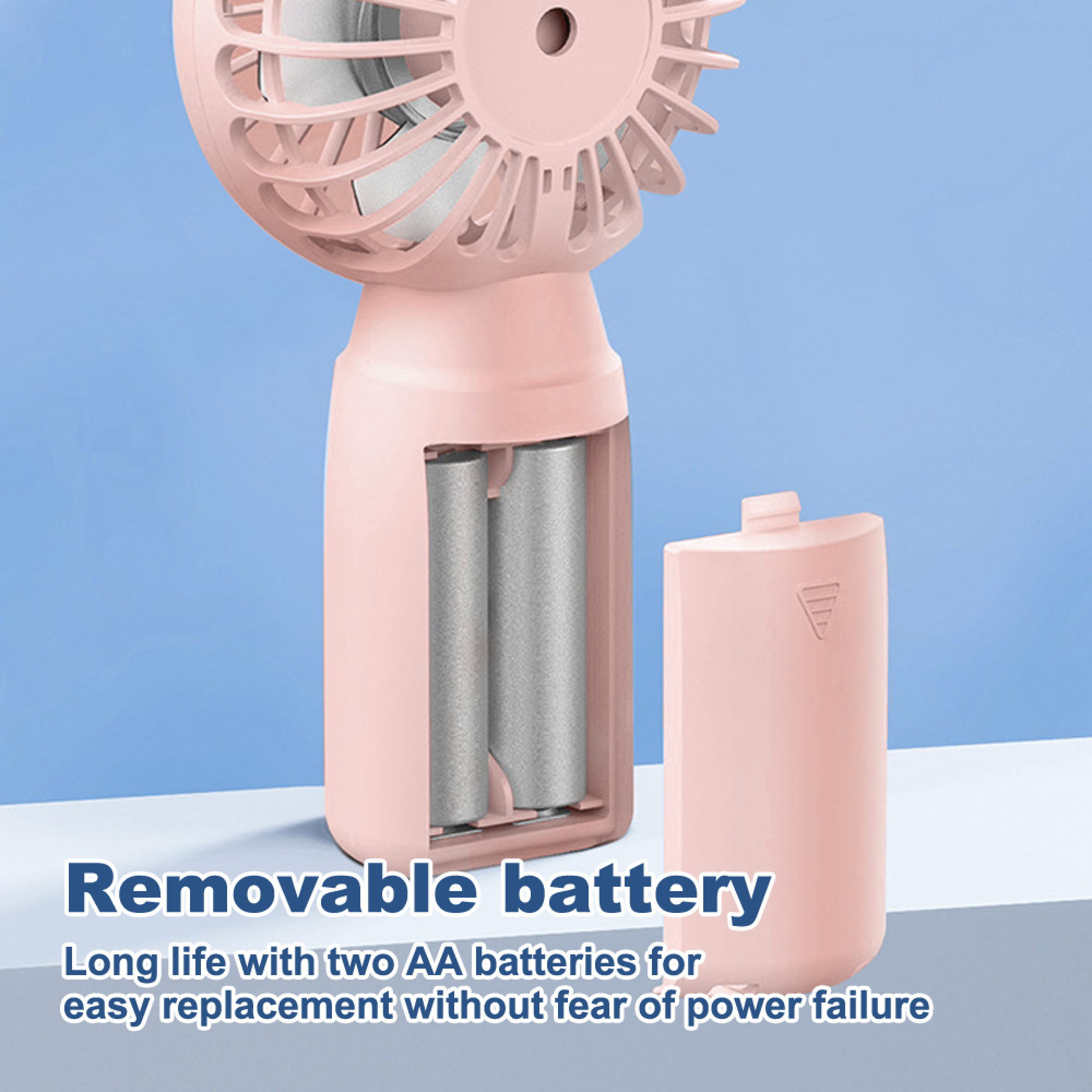 Ein rosa Ventilator mit entnommenem Batteriefach, das zwei AA-Batterien zeigt.