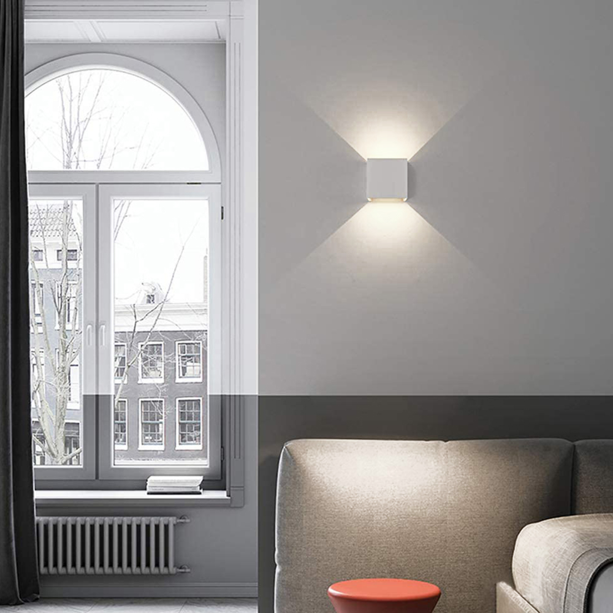 Ein modernes Wohnzimmer mit Fenster, Sofa und Wandleuchte.