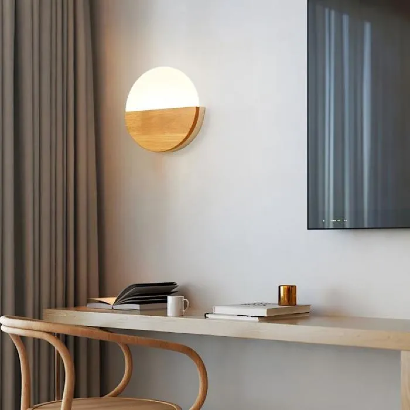 Eine moderne Wandlampe aus Holz und Glas sitzt über einem Schreibtisch mit Büchern und einer Tasse.