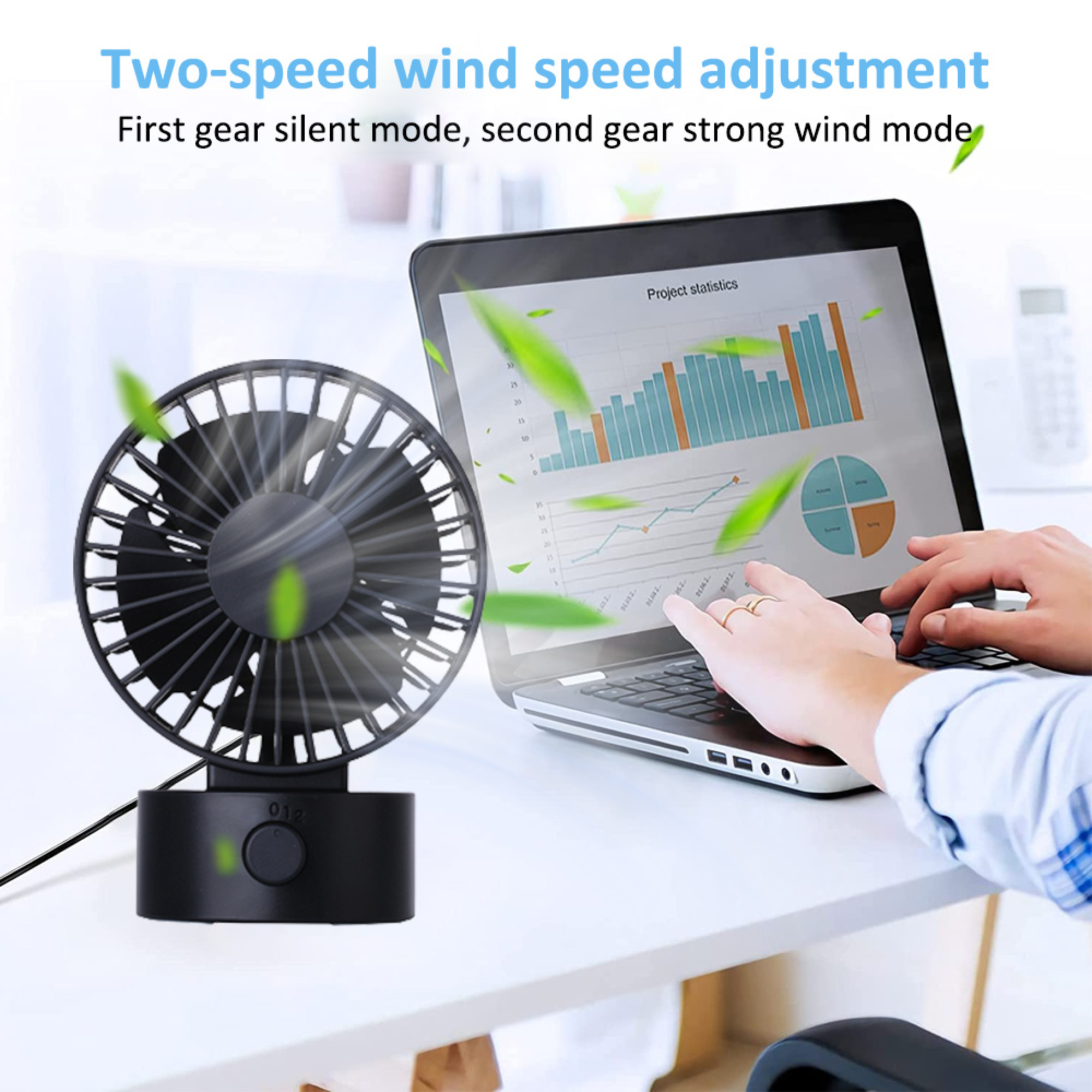 Ein schwarzer Schreibtischventilator neben einem Laptop mit Diagrammen. Grüne Blätter schweben.