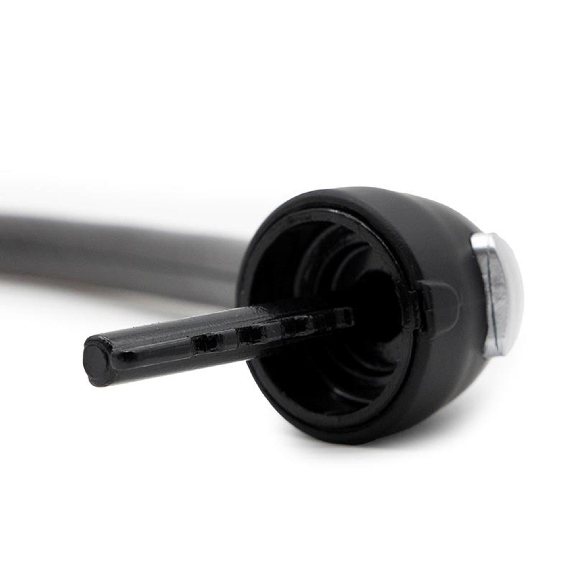 Una llave de plástico negra con punta plateada está insertada en un objeto cilíndrico negro.
